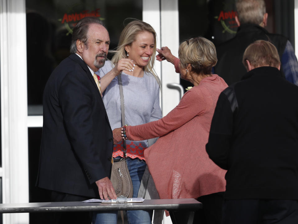 Dick Rotolo, left, and his wife, Sheri, right, greet a participant as they arrive to attend a faith-based memorial service for the victims of the massacre at Columbine High School nearly 20 years earlier at a community church, Thursday, April 18, 2019, in Littleton, Colo. (AP Photo/David Zalubowski)