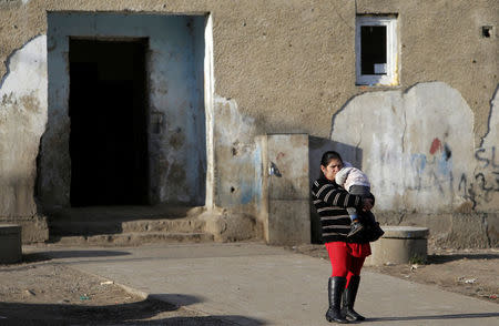 A Roma woman holds her baby as she stands at the so called "Sheffield Square" in the town of Bystrany, Slovakia, November 28, 2016. Picture taken November 28, 2016. REUTERS/David W Cerny