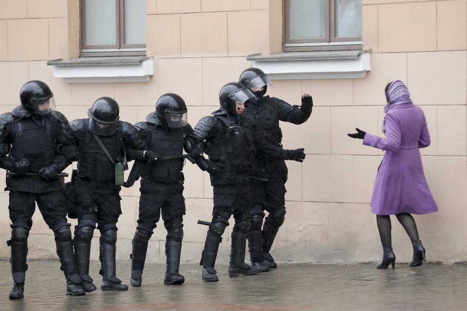 A woman argues as Belarus police block a street during an opposition rally in Minsk, Belarus, Saturday, March 25, 2017. A cordon of club-wielding police blocked the demonstrators' movement along Minsk's main avenue near the Academy of Science. Hulking police detention trucks were deployed in the city center. (AP Photo/Sergei Grits)