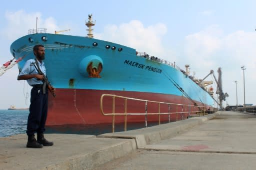 A security guard stands by a ship docked in the southern Yemeni port of Aden on October 29, 2018