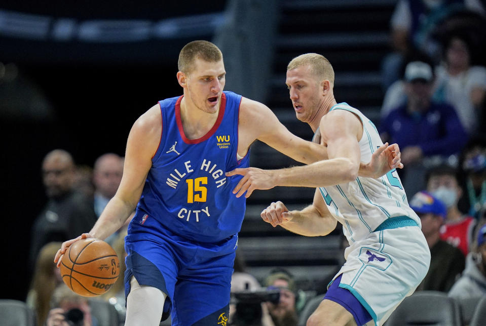 Denver Nuggets center Nikola Jokic (15) goes to the basket against Charlotte Hornets center Mason Plumlee, right, during the first half of an NBA basketball game on Monday, March 28, 2022, in Charlotte, N.C. (AP Photo/Rusty Jones)