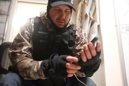 Wes Kjar, an occupier, check his phone in an office at the Malheur National Wildlife Refuge near Burns, Oregon, January 5, 2016. REUTERS/Jim Urquhart