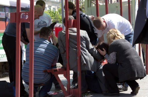 People try to help a woman injured by one of the blasts in the eastern Ukrainian city of Dnipropetrovsk, on April 27. President Viktor Yanukovych paid a visit to Ukraine's industrial heartland after the wave of blasts injured dozens of people