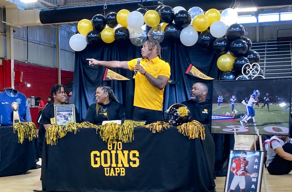  Jonathan Goins Jr., points to supporters during a celebration of his signing a national letter of intent to play football at the college level. (Jo Napolitano/The 74)