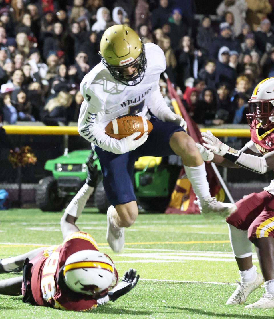 Archbishop Williams Matt Kowalski leaps over the Cardinal Spellman defender for a touchdown during a game on Wednesday, Nov. 24, 2021.