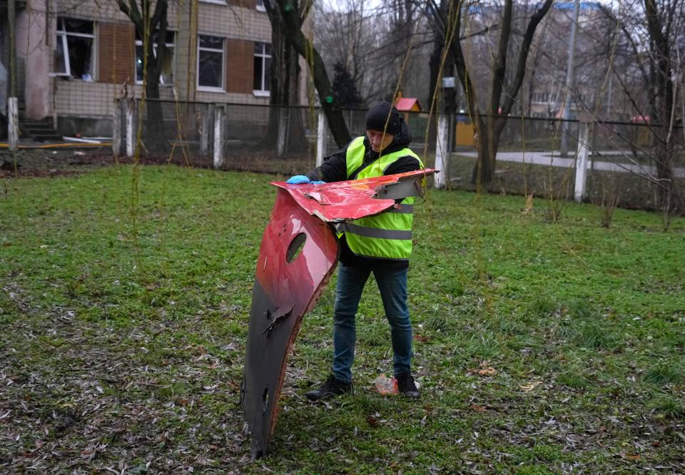 An expert examines a fragment of the helicopter (AP)