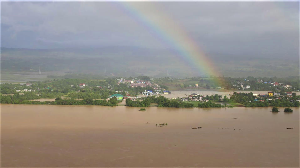 In this photo provided by the Philippine Coast Guard, a rainbow is seen above flooded areas in Cagayan valley region, northern Philippines Saturday, Nov. 14, 2020. Thick mud and debris coated many villages around the Philippine capital Friday after Typhoon Vamco caused extensive flooding that sent residents fleeing to their roofs and killing dozens of people. (Philippine Coast Guard via AP)