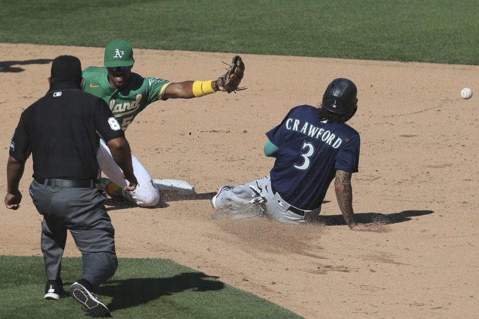 Seattle Mariners' J.P. Crawford (3) steals second base as Oakland Athletics' Tony Kemp waits for the throw during the eighth inning of the first baseball game of a doubleheader in Oakland, Calif., Saturday, Sept. 26, 2020. (AP Photo/Jed Jacobsohn)