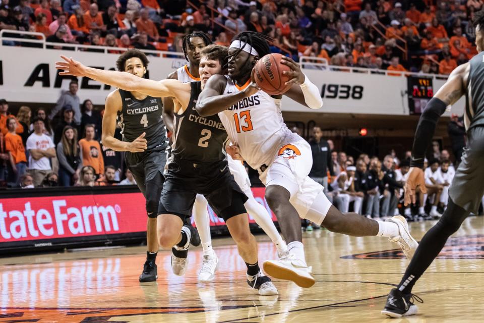 Jan 26, 2022; Stillwater, Oklahoma, USA; Oklahoma State Cowboys guard Isaac Likekele (13) moves to the basket while defended by Iowa State Cyclones guard Caleb Grill (2) during the first half at Gallagher-Iba Arena. Mandatory Credit: Rob Ferguson-USA TODAY Sports