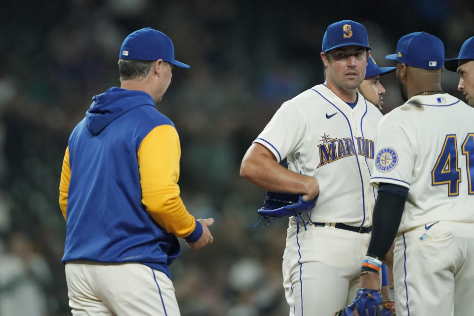 Seattle Mariners starting pitcher Robbie Ray, second from left, looks at manager Scott Servais, left, as Servais arrives to pull him during the seventh inning of a baseball game against the Oakland Athletics, Sunday, July 3, 2022, in Seattle. (AP Photo/Ted S. Warren)