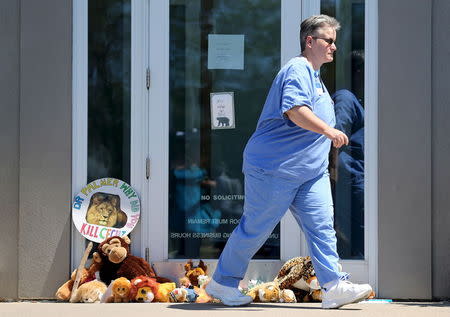 A woman leaves a note taped to the doorway of River Bluff Dental clinic in protest against the killing of a famous lion in Zimbabwe, in Bloomington, Minnesota July 29, 2015. REUTERS/Eric Miller