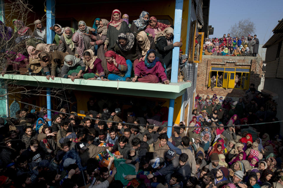 Kashmiri village women watch as men carry the body of a local rebel Muzamil Ahmed Dar during his funeral procession in Rahmoo village south of Srinagar, Indian controlled Kashmir, Saturday, Dec. 29, 2018. Anti-India protests and clashes erupted in disputed Kashmir on Saturday after a gunbattle between militants and government forces killed four rebels, police and residents said. (AP Photo/ Dar Yasin)