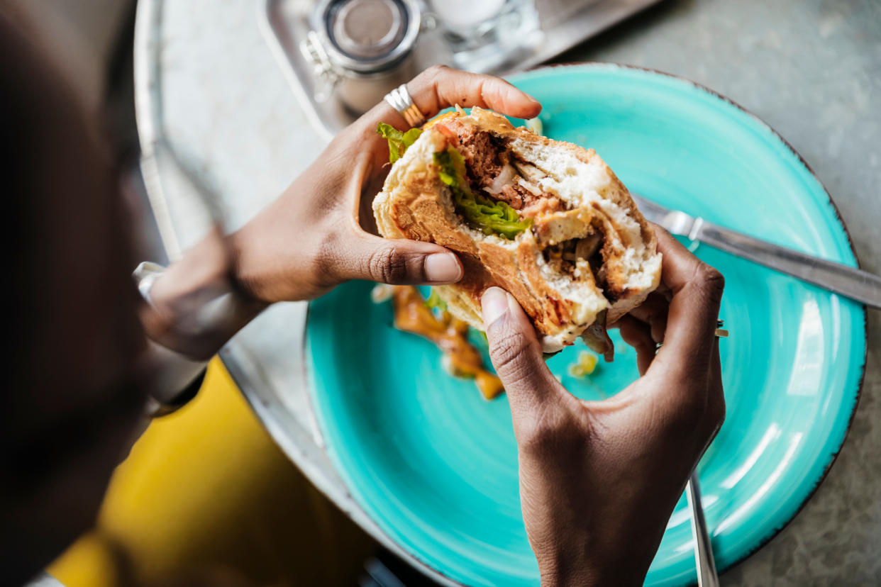 A close up of a woman eating a vegan diet meal in a local cafe with friends.