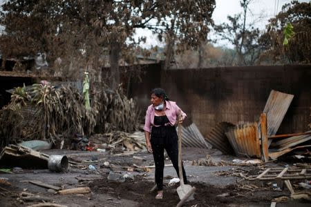 Eufemia Garcia, 48, who lost 50 members of her family during the eruption of the Fuego volcano, rests holding a shovel while searching for her family in San Miguel Los Lotes in Escuintla, Guatemala, June 15, 2018. REUTERS/Carlos Jasso