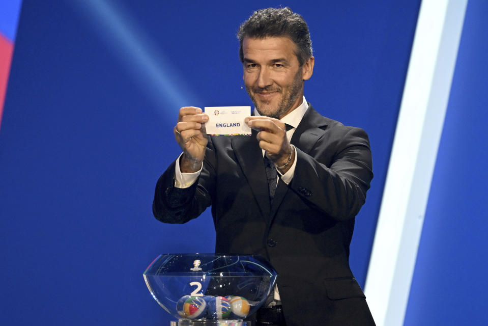 Karl-Heinz Riedle, former soccer player and soccer official, holds the lot of England during the draw for the groups to qualify for the 2024 European soccer championship in Frankfurt, Germany, Sunday, Oct.9, 2022. (Arne Dedert/dpa via AP)