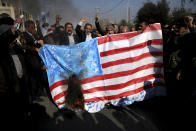 <p>Iranian worshippers chant slogans while they burn a representation of U.S. flag during a rally against anti-government protestors after the Friday prayer ceremony in Tehran, Iran, Jan. 5, 2018. (Photo: Ebrahim Noroozi/AP) </p>