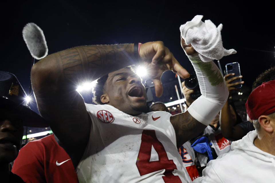 Alabama quarterback Jalen Milroe celebrates as he walks off the field after defeating Auburn in an NCAA college football game Saturday, Nov. 25, 2023, in Auburn, Ala. (AP Photo/Butch Dill)