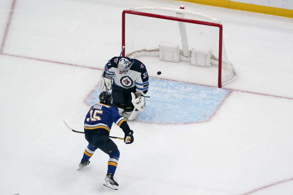 St. Louis Blues' Jakub Vrana (15) scores past Winnipeg Jets goaltender Connor Hellebuyck (37) during the third period of an NHL hockey game Sunday, March 19, 2023, in St. Louis. (AP Photo/Jeff Roberson)