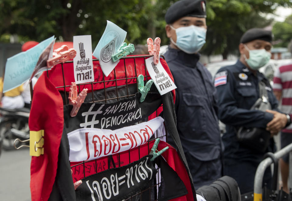 Police officers stand guard next to merchandise promoting the pro-democracy movement outside the Parliament during a rally in Bangkok, Thailand, Thursday, Sept. 24, 2020. Lawmakers in Thailand are expected to vote Thursday on six proposed amendments to the constitution, as protesters supporting pro-democratic charter reforms gathered outside the parliament building. (AP Photo/Gemunu Amarasinghe)