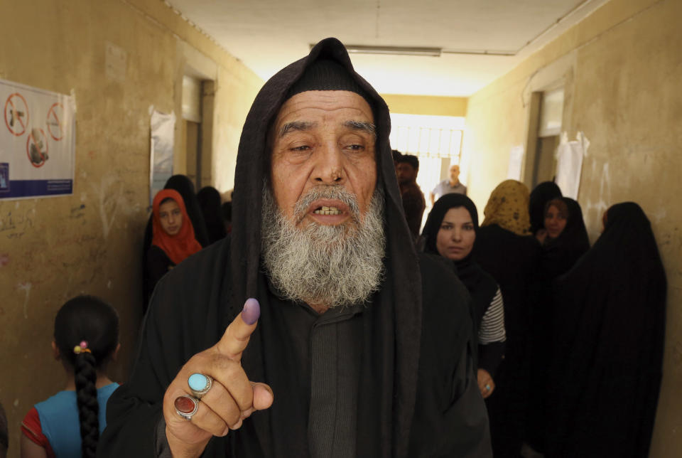 An Iraqi elderly man shows his ink-stained finger after casting his vote inside a polling station for parliamentary elections in Baghdad, Iraq, Wednesday, April 30, 2014. Iraq is holding its third parliamentary elections since the U.S.-led invasion that toppled dictator Saddam Hussein. More than 22 million voters are eligible to cast their ballots to choose 328 lawmakers out of more than 9,000 candidates. (AP Photo/Karim Kadim)