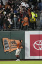 San Francisco Giants left fielder Thairo Estrada watches as fans try to catch the ball on a home run by Houston Astros' Jose Altuve during the fifth inning of a baseball game Friday, July 30, 2021, in San Francisco. (AP Photo/Tony Avelar)