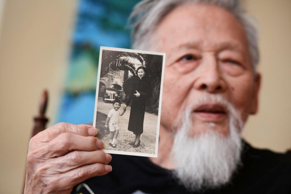 Pax Cheng holds a photo of him and his mother, taken when he was a young boy growing up in China. Cheng recalls being involved as an 11-year-old in efforts to help the Doolittle Raiders after their bombing raid on Japan during World War II.