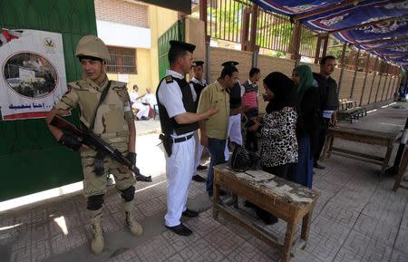 Voters present papers at a polling station in the El Sayda Zeinab area on the third day of voting in the Egyptian presidential elections in Cairo, May 28, 2014. REUTERS/Amr Abdallah Dalsh