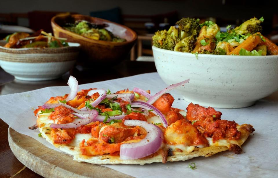The lunch combo of Chicken Tikka Naan Flatbread, front, with Roasted Veggie Salad, rear, is one of the many unique dining experiences offered at Chaska in Garden City.