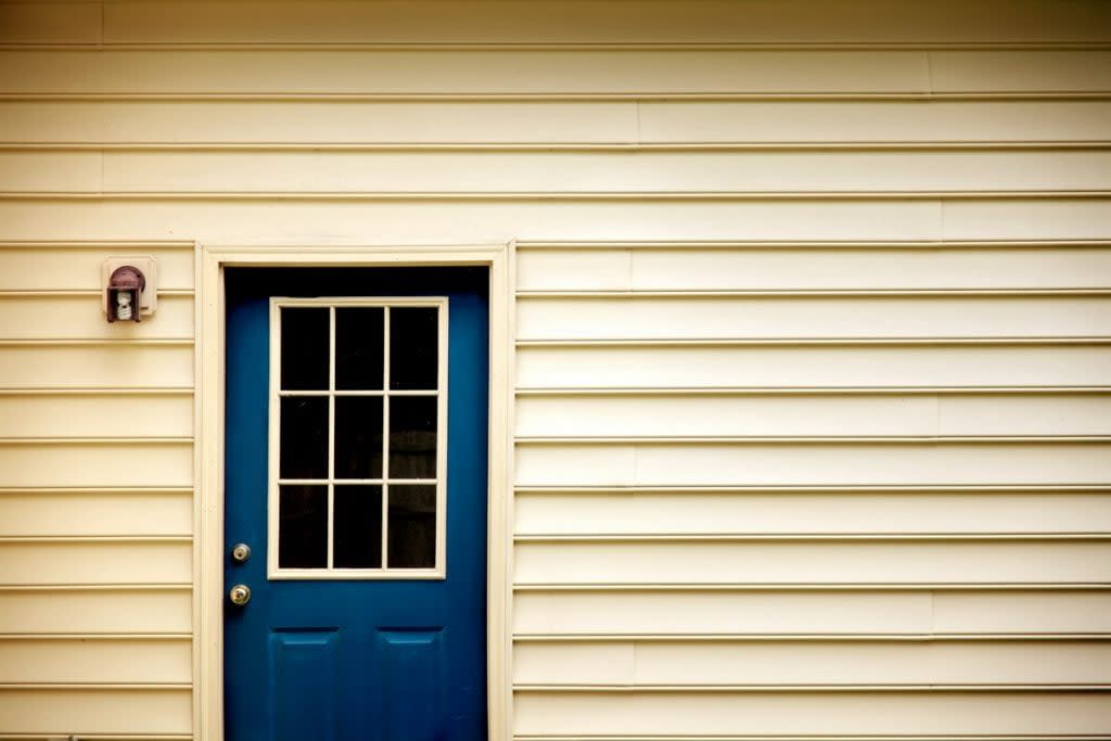 A blue door is shown on the exterior of a home. Single-premium mortgage insurance, also called single-payment mortgage insurance, requires buyers to pay for the mortgage insurance in one lump sum payment on the day of closing.