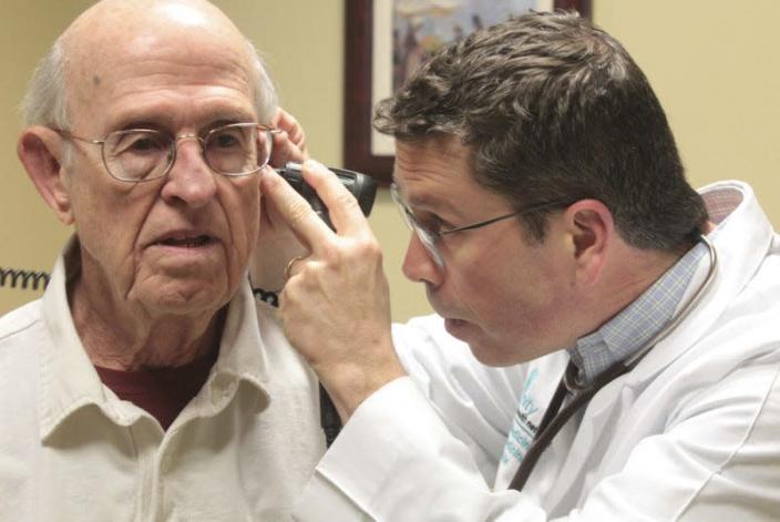 Le Dr Troy Bishop (à droite) examine l'oreille de son patient William Bach, 81 ans, lors d'un examen du Unity Health Network le mardi 6 mars 2018.