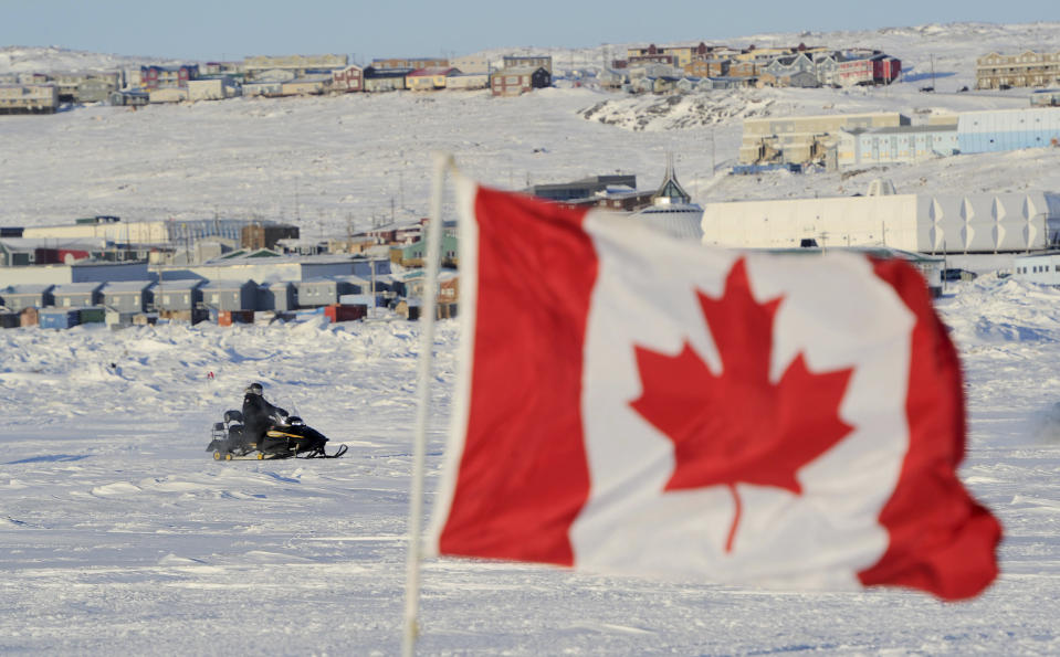 Canadian Prime Minister Stephen Harper rides a snowmobile in Frobisher Bay in Iqaluit, Nunavut, February 23, 2012. REUTERS/Sean Kilpatrick/Pool (CANADA)