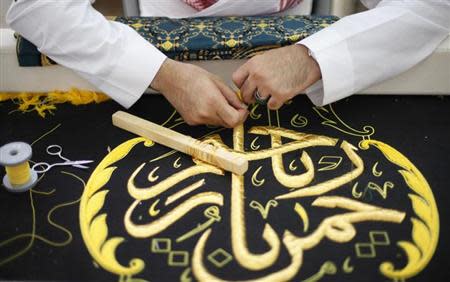 A worker embroiders the Kiswa, a silk cloth covering the Holy Kaaba, in the holy city of Mecca, ahead of the annual haj pilgrimage October 8, 2013. REUTERS/Ibraheem Abu Mustafa