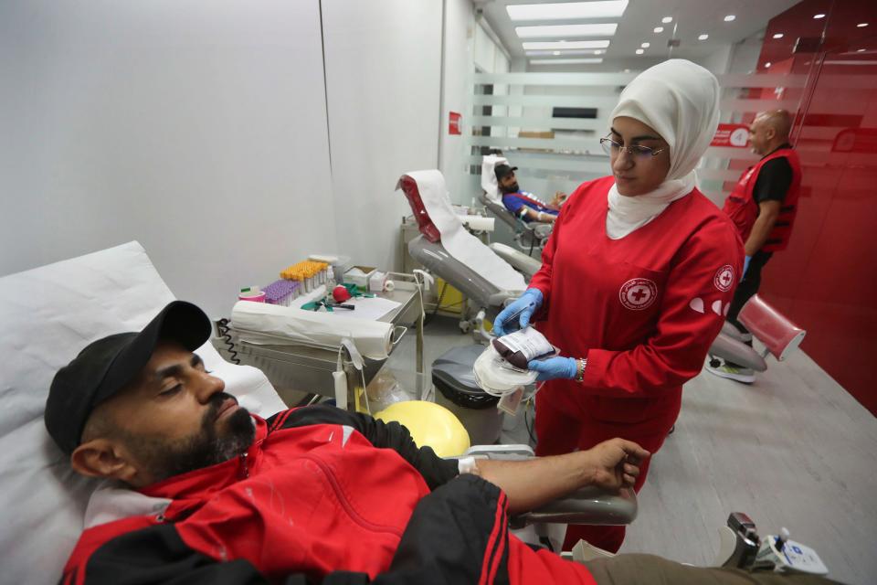 People donate blood for those who were injured by their exploded handheld pagers, at a Red Cross center, in the southern port city of Sidon, Lebanon, Tuesday, Sept. 17, 2024. (AP Photo/Mohammed Zaatari)