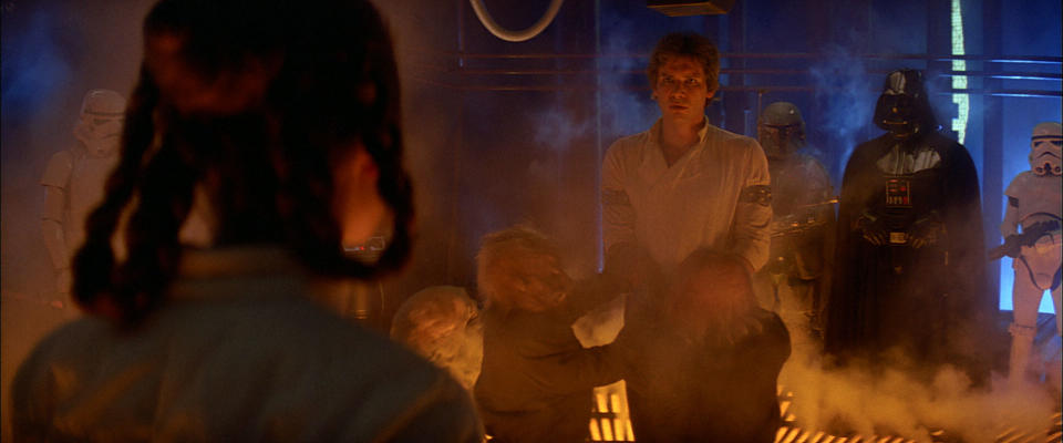 Han Solo is manhandled into position by ugnaughts. (Lucasfilm) 