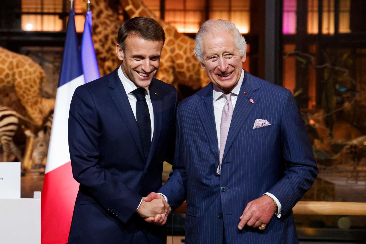 French President Emmanuel Macron shakes hands with Britain's King Charles III during their visit to the Museum of Natural History (POOL/AFP via Getty Images)