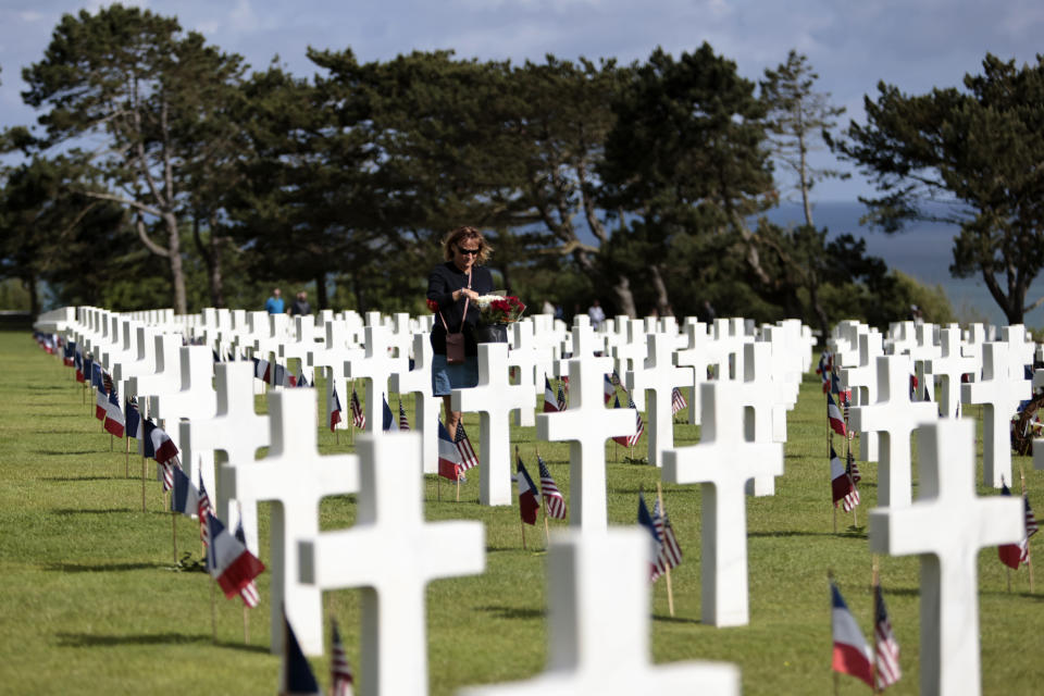 A woman holds a bouquet of roses during the 78th anniversary of D-Day ceremony, in the Normandy American Cemetery and Memorial of Colleville-sur-Mer, overlooking Omaha Beach, Monday, June, 6, 2022. The ceremonies pay tribute to the nearly 160,000 troops from Britain, the U.S., Canada and elsewhere who landed on French beaches on June 6, 1944, to restore freedom to Europe after Nazi occupation. (AP Photo/ Jeremias Gonzalez)