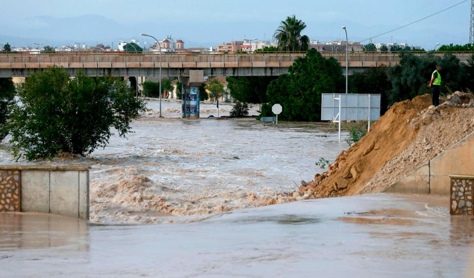 A man stands next to the overflowed Segura river in Almoradi on September 14. (AFP/Getty Images)