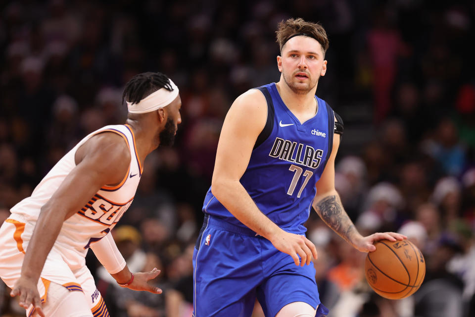 PHOENIX, ARIZONA - DECEMBER 25: Luka Doncic #77 of the Dallas Mavericks handles the ball under pressure from Josh Okogie #2 of the Phoenix Suns during the first half of the NBA game at Footprint Center on December 25, 2023 in Phoenix, Arizona. NOTE TO USER: User expressly acknowledges and agrees that, by downloading and or using this photograph, User is consenting to the terms and conditions of the Getty Images License Agreement.  (Photo by Christian Petersen/Getty Images)
