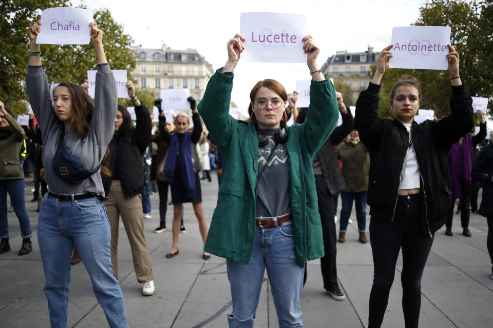 FILE - In this Oct.19, 2019 file photo, women hold placards with the names of women killed by their partners, during a protest, in Paris. A French government commission examining domestic violence is recommending that authorities now confiscate firearms from individuals following the first complaint of family violence levied against them. In France, a woman is killed by her partner every three days, according to government statistics. (AP Photo/Thibault Camus, File)