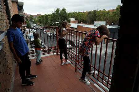 The Stan children check out their new neighbourhood from their balcony after being relocated from El Gallinero shanty town into a public housing apartment in Madrid, Spain, September 26, 2018. REUTERS/Susana Vera