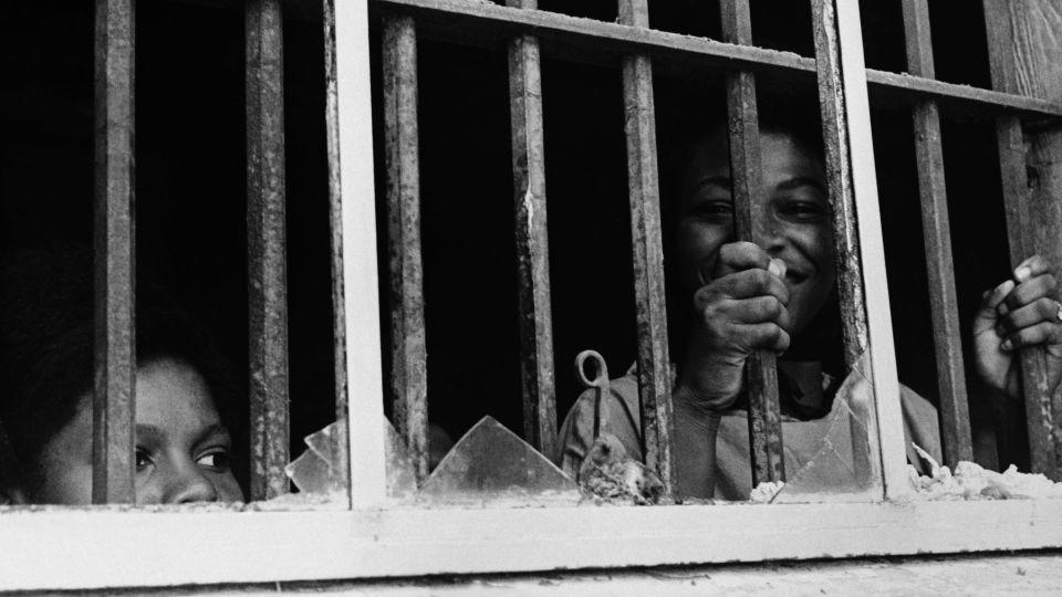 Shirley Reese holds onto the bars of the stockade window in Leesburg, Georgia, in 1963. - Danny Lyon/Magnum Photos