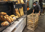 Baker Ludovic Laurent pushes a basket of baguettes at Bigot bakery in Versailles, west of Paris, Tuesday, Oct. 26, 2021. A worldwide increase in wheat prices after bad harvests in Russia is forcing French bakers to raise the price of that staple of life in France the baguette. Boulangeries around France have begun putting up signs warning their customers of an increase in the price of their favourite bread due to rising costs. (AP Photo/Michel Euler