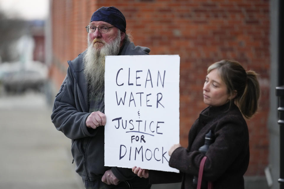 Ray Kemble, left, of Dimock, Pa., and Renee Vogelsang hold a sign outside the Susquehanna County Courthouse in Montrose, Pa., Tuesday, Nov. 29, 2022. Pennsylvania's most active gas driller has pleaded no contest to criminal environmental charges in a landmark pollution case. Houston-based Coterra Energy Inc. entered its plea Tuesday. (AP Photo/Matt Rourke)