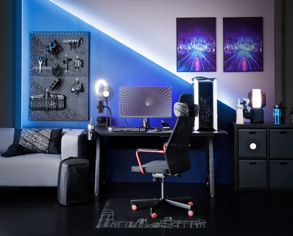 A blue hued room full of cyberpunk style gaming furniture.