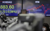 A currency trader watches computer monitors near the screen showing the Korean Securities Dealers Automated Quotations (KOSDAQ) at the foreign exchange dealing room in Seoul, South Korea, Friday, Sept. 11, 2020. Asian shares were mixed Friday following a selloff of technology shares on Wall Street. (AP Photo/Lee Jin-man)