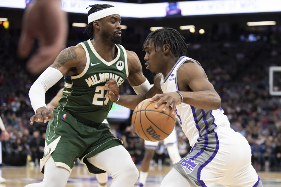 Milwaukee Bucks guard Wesley Matthews (23) defends against Sacramento Kings guard Davion Mitchell (15) during the first quarter of an NBA basketball game in Sacramento, Calif., Wednesday, March 16, 2022. (AP Photo/José Luis Villegas)