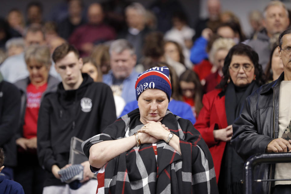 A woman prays during the invocation at the start of a campaign rally for President Donald Trump in Bossier City, La., Thursday, Nov. 14, 2019. (AP Photo/Gerald Herbert)