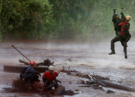 A soldier helps a member of a rescue team on Paraopeba River as they search for victims of a collapsed tailings dam owned by Brazilian mining company Vale SA, in Brumadinho, Brazil February 5, 2019. REUTERS/Adriano Machado