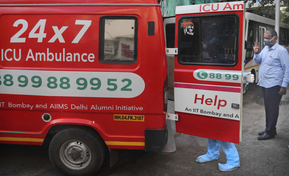 Izhaar Hussain Shaikh, second right, an ambulance driver who works for HelpNow, an initiative to help the stretched services of first responders, helps a COVID-19 patient get into the ambulance in Mumbai, India May 29, 2020. It’s an exhausting job and Shaikh's daily shifts are grueling, sometimes even stretching to 16 hours. For a city that has a history of shortage of ambulances and where coronavirus pandemic has claimed hundreds of lives, putting the health care system under immense strain, every help counts. (AP Photo/Rafiq Maqbool)