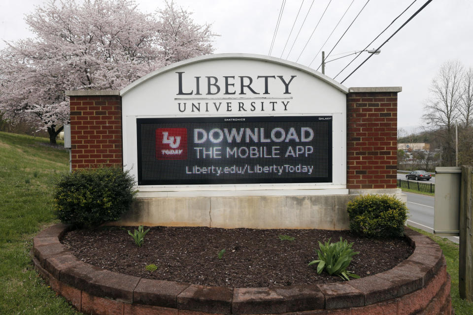 FILE - In this March 24, 2020 file photo, a sign marks the entrance to Liberty University, Tuesday March 24 , 2020, in Lynchburg, Va. Jerry Falwell Jr. said Tuesday, Aug. 25, that he has resigned as head of evangelical Liberty University because of ongoing controversies about his wife’s sexual involvement with a younger business partner and in the wake of a social media photo that caused an uproar. (AP Photo/Steve Helber)